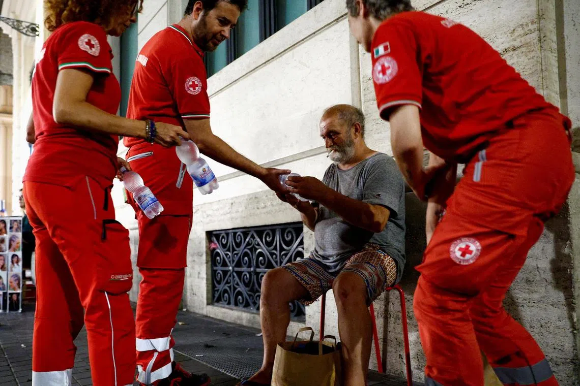 Red Cross workers Chiara Amantis, Igor Bertello and Anna Milazzo on Friday giving bottles of water to Antonio, who is homeless and fainted a few days ago because of the heat. Like Italy, other southern European countries like Greece and Spain have also been grappling with extreme heat this month. REUTERS