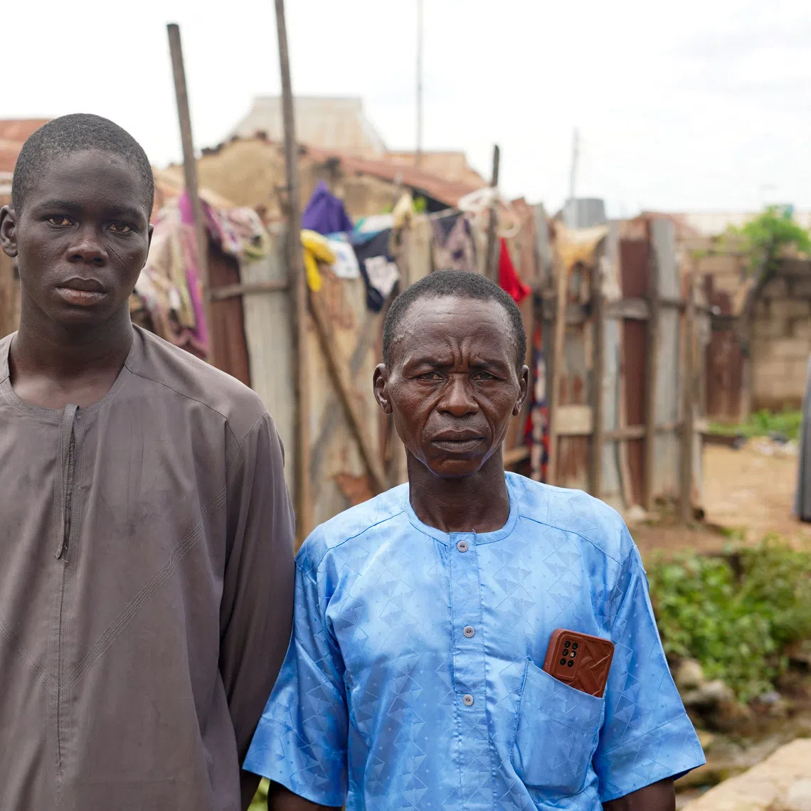 Adamu Isah, 22, a survivor, stands with his father at their home after returning from detention in Niger State, Nigeria, September 19, 2026. Isah recounted his experience following reports that 37 detained miners died while in the custody of the Nigeria Security and Civil Defence Corps. REUTERS/Ibrahim Ndamitso