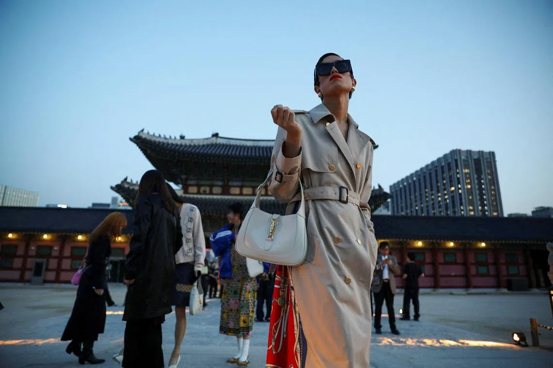 A woman posing for photographs after Gucci Cruise 2024 collection fashion show at the Gyeongbok Palace in Seoul, South Korea, May 16.