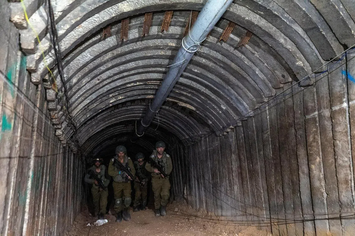 Israeli soldiers are seen walking through a Hamas-designed iron-girded tunnel, intended to deploy Palestinian fighters for a surprise border assault. This unfolds during the ongoing Israeli army operation against Hamas near Erez crossing in the northern Gaza Strip on Dec 15, 2023.