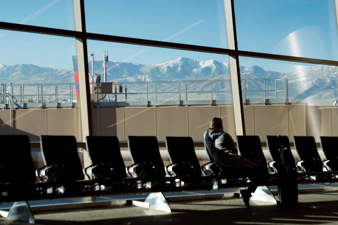 FILE PHOTO: With the Wasatch Mountains in the background, a passenger waits at an airline gate at Salt Lake City International Airport in Salt Lake City, Utah, U.S., November 1, 2024.  REUTERS/Kevin Lamarque/File Photo