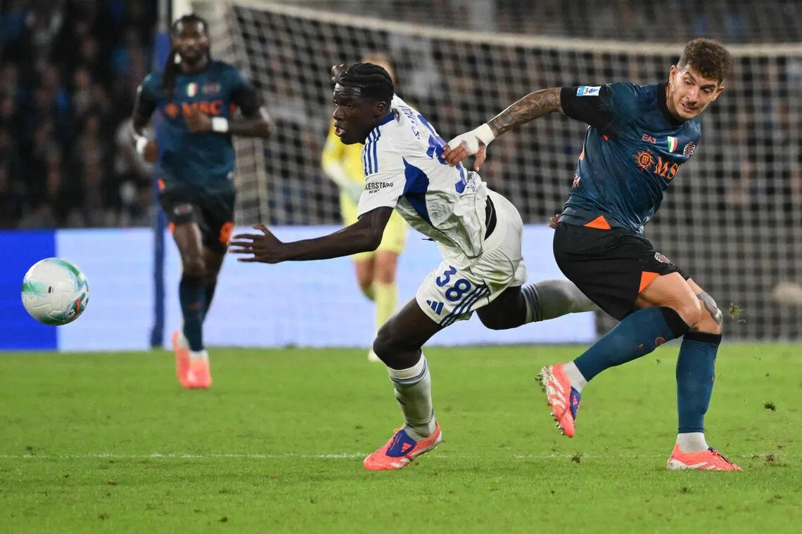 Como's Senegalese forward Assane Diao is tackled by Napoli's Italian defender Giovanni di Lorenzo in the Italian Serie A football match at the Diego Armando Maradona stadium on Nov 1, 2025.