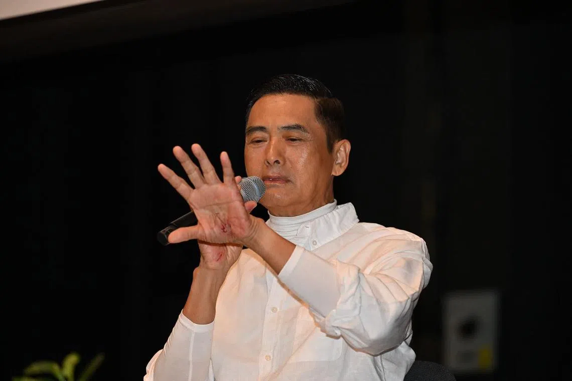 Chow Yun Fat at a talk at The University of Hong Kong on July 28, in which his palm injuries were visible.