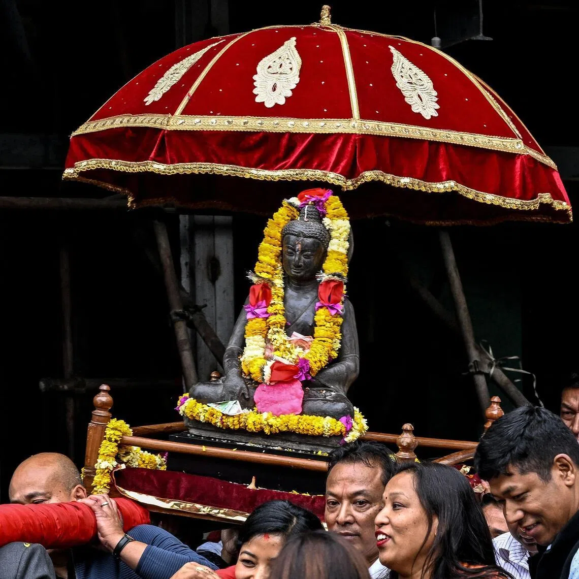 Devotees carrying a centuries-old Buddha statue stolen in the 1980s, back to its pagoda-style temple in Kathmandu on May 1.