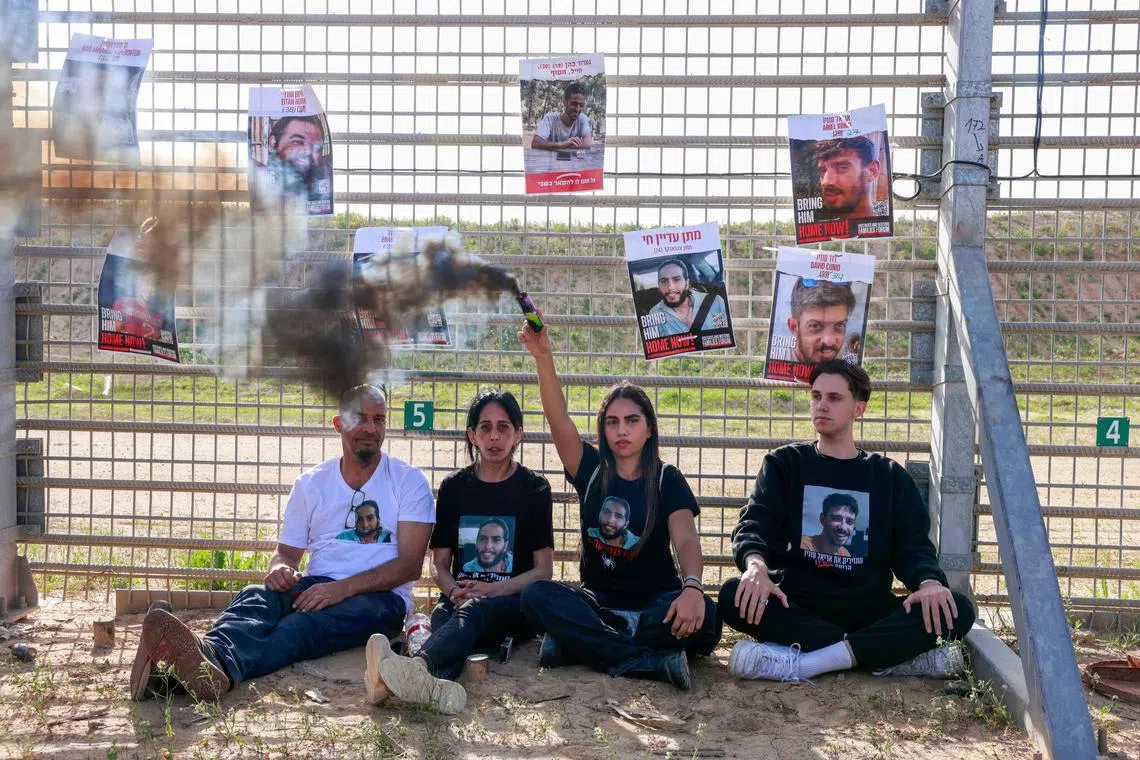 Einav Zangauker (2L), the mother of Israeli Matan Zangauer held hostage with others in the Gaza Strip since October 2023, sits alongside supporters and relatives at the Gaza border near kibbutz Nir Oz on March 18, 2025, to protest Israel's extensive strikes on the Palestinian territory, and demand preserving the truce and bringing the remaining hostages back with a deal. (Photo by Menahem KAHANA / AFP)