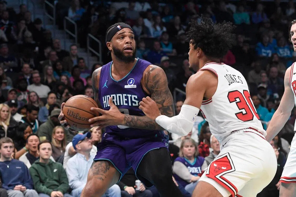 Charlotte Hornets forward Miles Bridges looking to pass as he is defended by Chicago Bulls guard Tre Jones during the first half of the Hornets' 123-116 NBA win at the Spectrum Center on Nov 28, 2025.