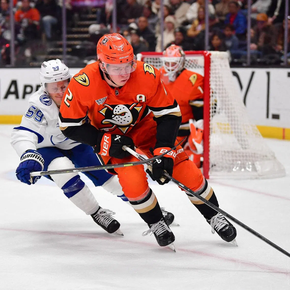 FILE PHOTO: Dec 31, 2025; Anaheim, California, USA; Anaheim Ducks defenseman Jackson Lacombe (2) moves the puck against Tampa Bay Lightning center Jake Guentzel (59) during the first period at Honda Center. Mandatory Credit: Gary A. Vasquez-Imagn Images/File Photo