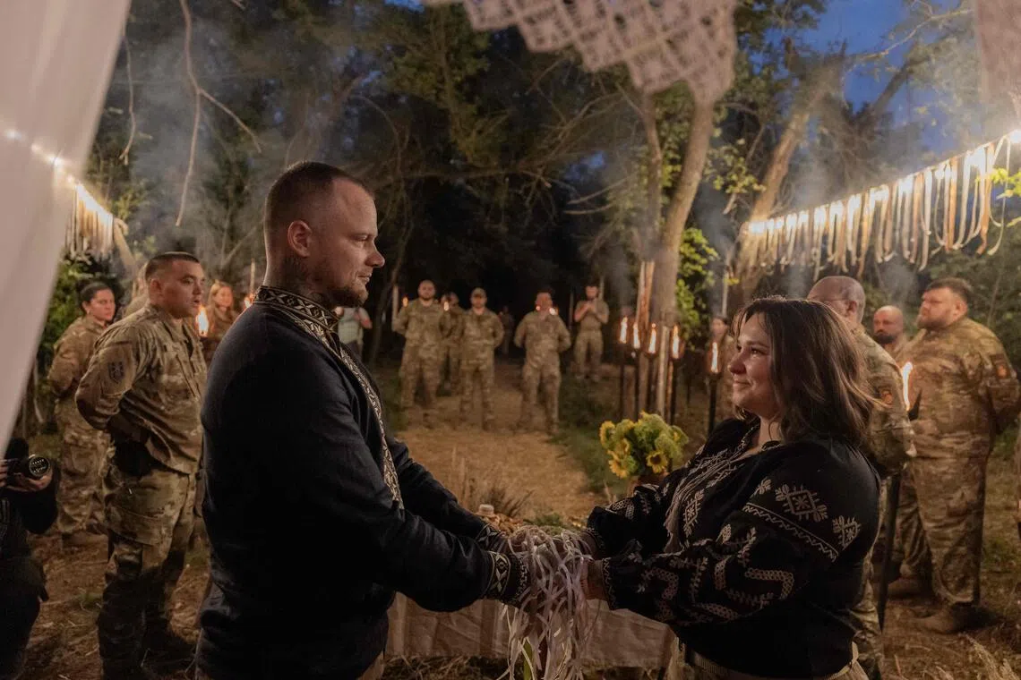 Two soldiers exchanged wedding vows during a Slavic ritual honouring ancestors and fallen warriors.