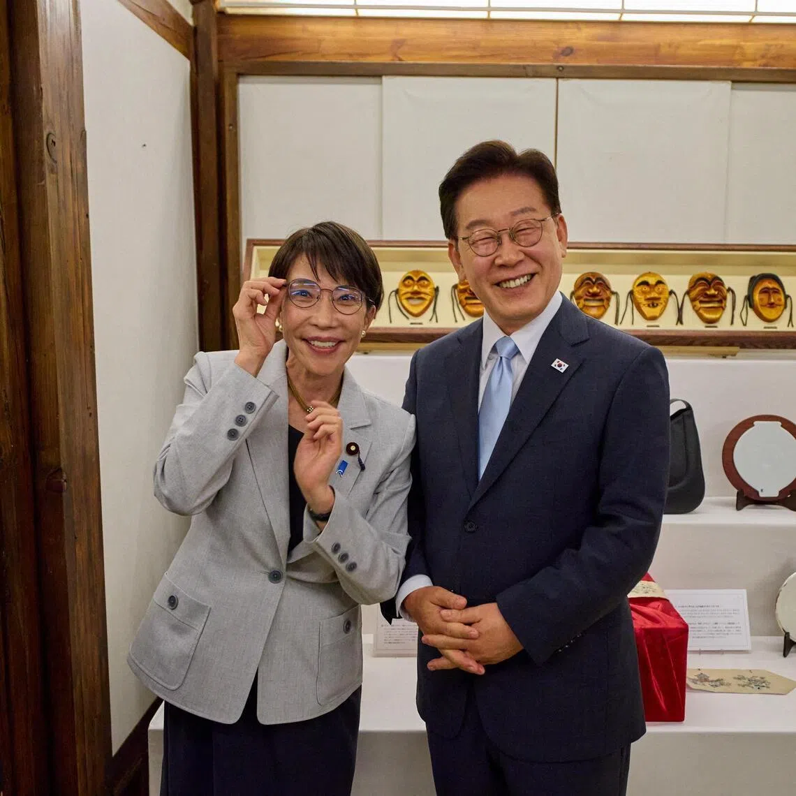 Japanese Prime Minister Sanae Takaichi poses for photographs with glasses received from South Korean President Lee Jae Myung, in Andong, South Korea, on May 19, 2026.