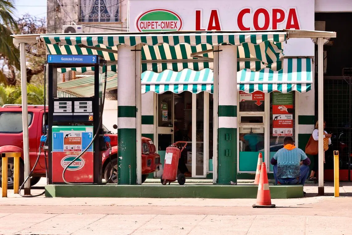 A person sits at a gas station in Havana on Feb 9. The country is facing a shortage of jet fuel, highlighting the severe impact of US energy restrictions on an island already grappling with a serious economic crisis.  