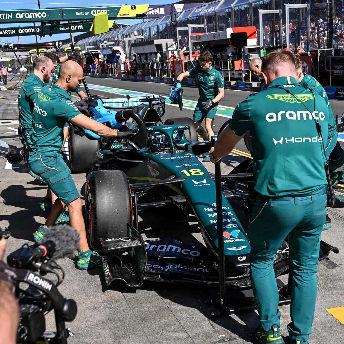 Aston Martin mechanics work on the car of Canadian driver Lance Stroll in the pits during the second practice session of the Australian Grand Prix.