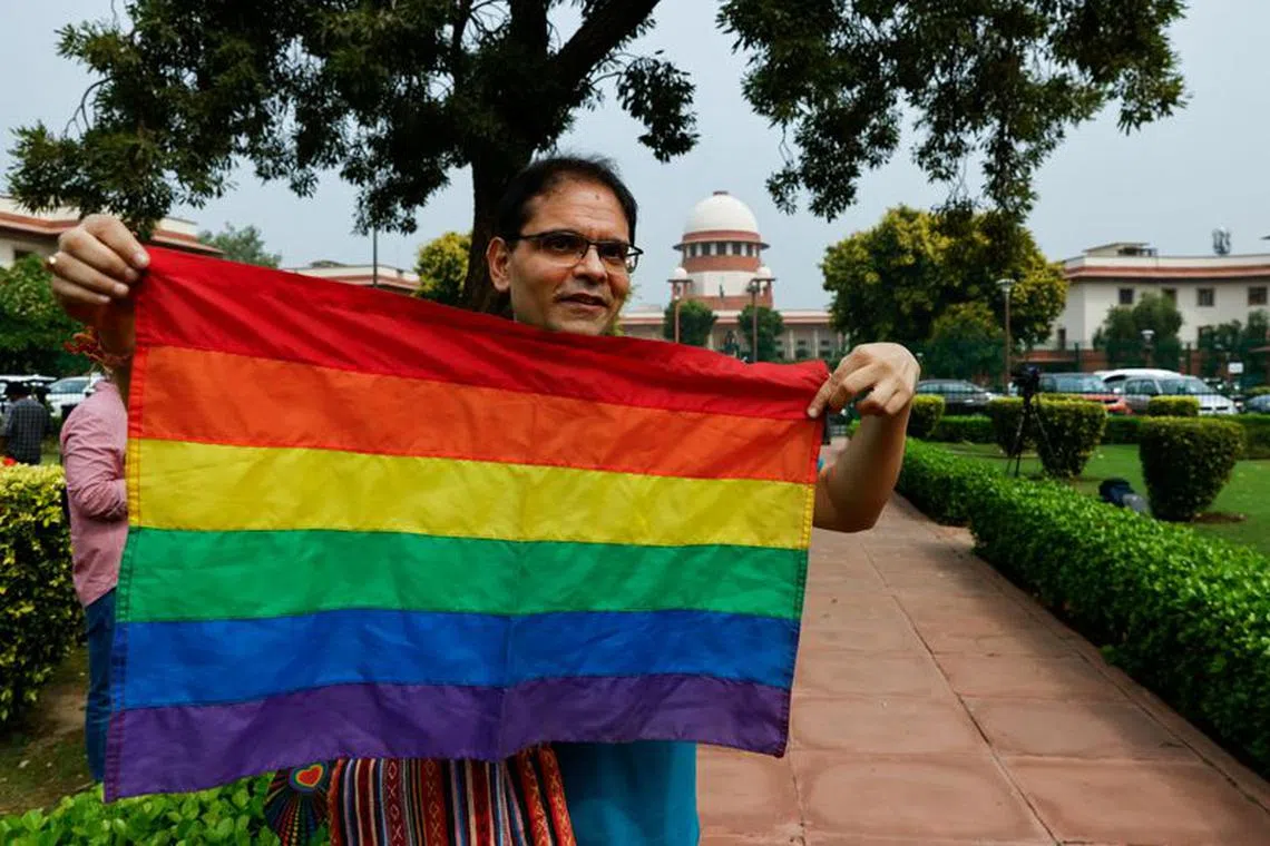 A writer and member of the lesbian, gay, bisexual and transgender community (LGBT community) holds the pride flag while waiting to hear the judgement on same-sex marriage by the Supreme Court in New Delhi, India, October 17, 2023. REUTERS/Anushree Fadnavis