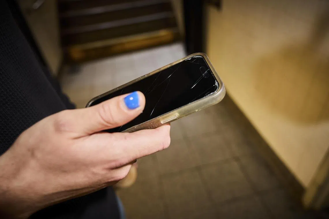 A man observes his smartphone with a darkened screen protector in New York, June 9, 2025. The darkened screen protectors are meant to swat away those who like to see what others are up to on their devices. 