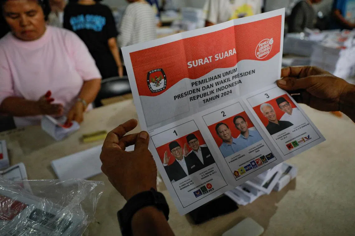 An officer of the election commission shows a ballot paper for the upcoming presidential election, as it being folded at a warehouse in Jakarta, Indonesia, January 8, 2024. REUTERS/Willy Kurniawan