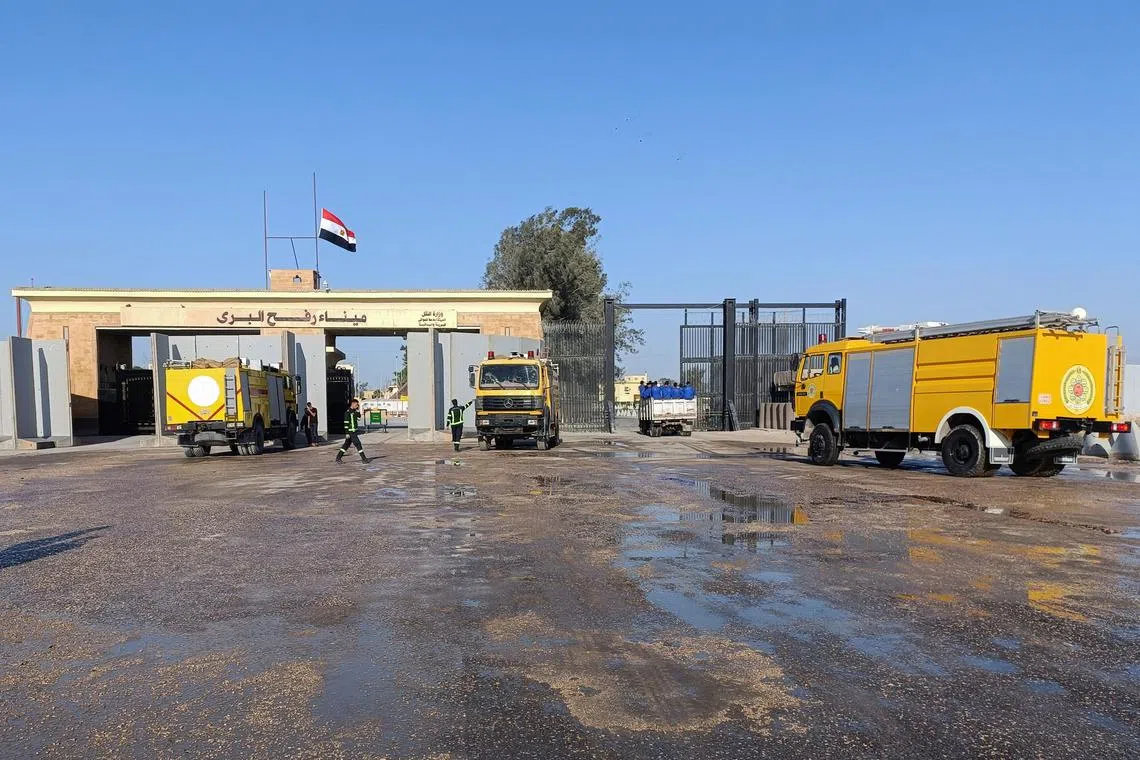 Egyptian fire trucks in front of the Rafah crossing from the Egyptian side, and trucks carrying humanitarian aid for Palestinians await to enter Gaza.