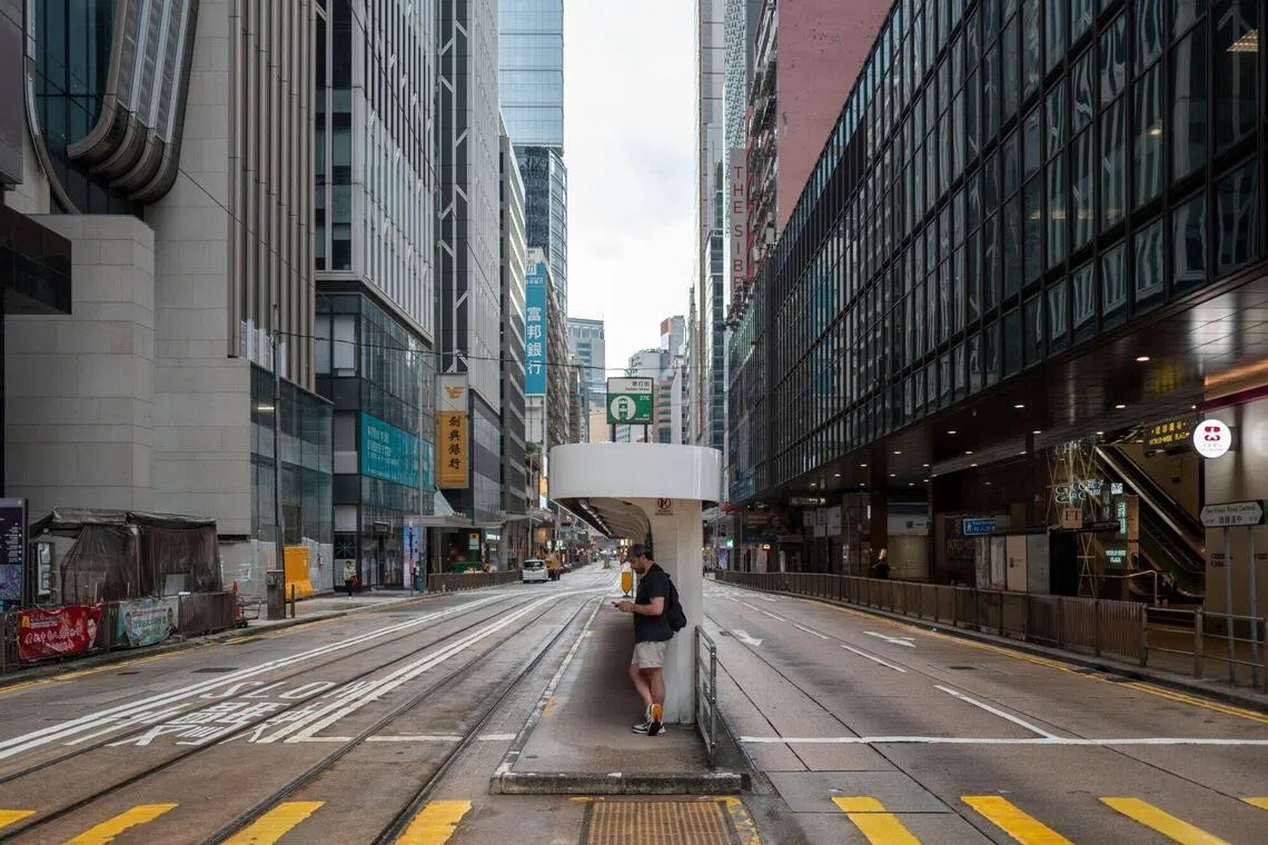 A pedestrian at a tram station at a near empty street in Central district during Super Typhoon Ragasa in Hong Kong on Sept. 23, 2025. 