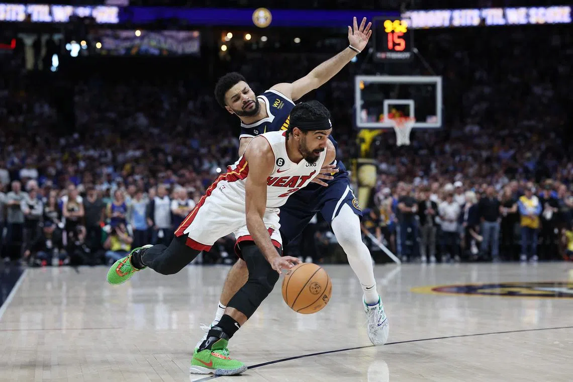 Gabe Vincent of the Miami Heat dribbles against Jamal Murray of the Denver Nuggets during Game 2 of the NBA Finals.
