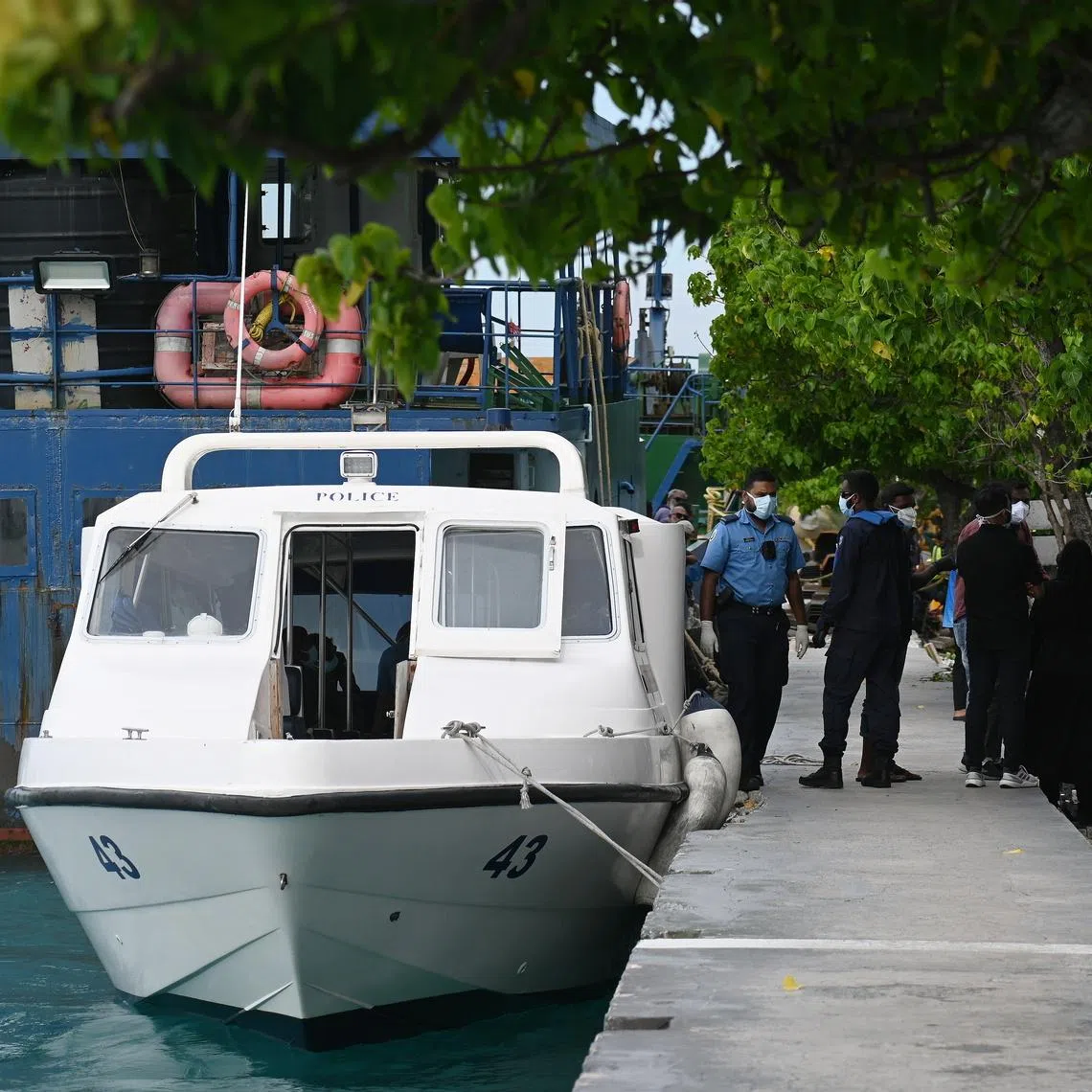 The bodies of two Italian divers being transferred from a police boat to an ambulance in Male on May 19.
