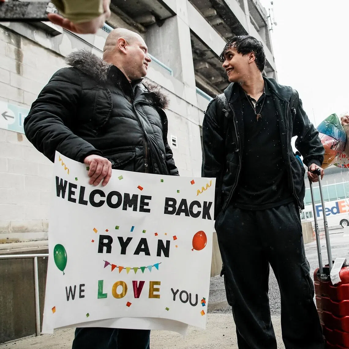 Mr Ryan Rivera speaking with his father at JFK international airport in New York on March 5, after arriving aboard a US government chartered flight.