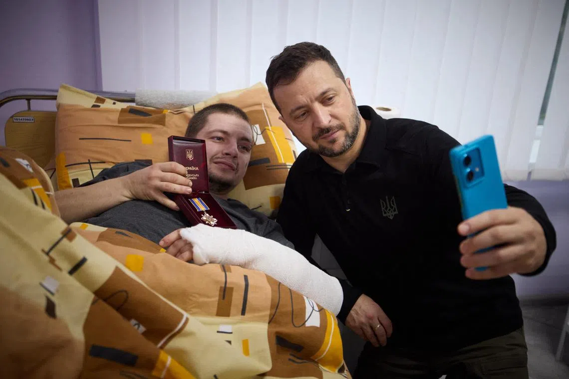 Ukrainian President Volodymyr Zelensky (right) taking a selfie with a wounded Ukrainian serviceman at a hospital in Sumy, near the border with Russia, on Oct 4.
