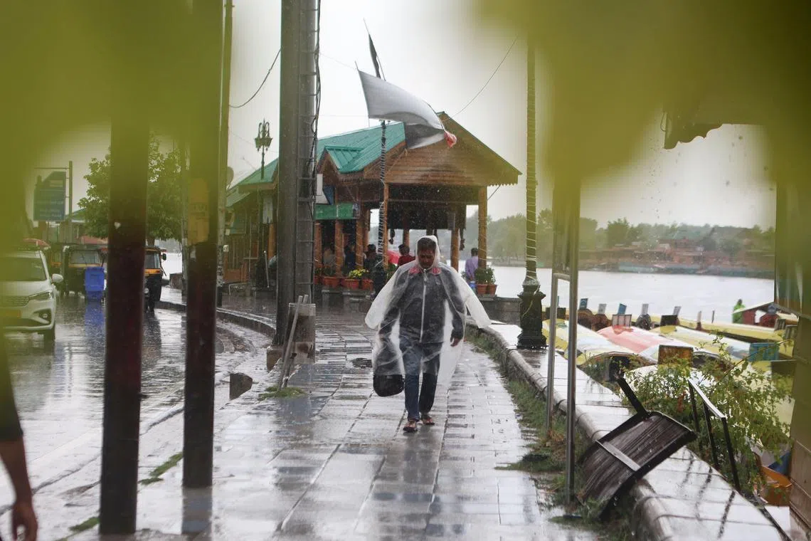 A man walks during rain in Kashmir, India on Aug 1.