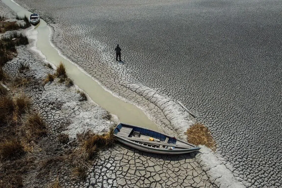 Manuel Flores walks on a dry area that shows the drop in the level of Lake Titicaca, Latin America's largest freshwater basin, as it is edging towards record low levels, on Cojata Island, Bolivia October 26, 2023.       REUTERS/Claudia Morales/File photo
