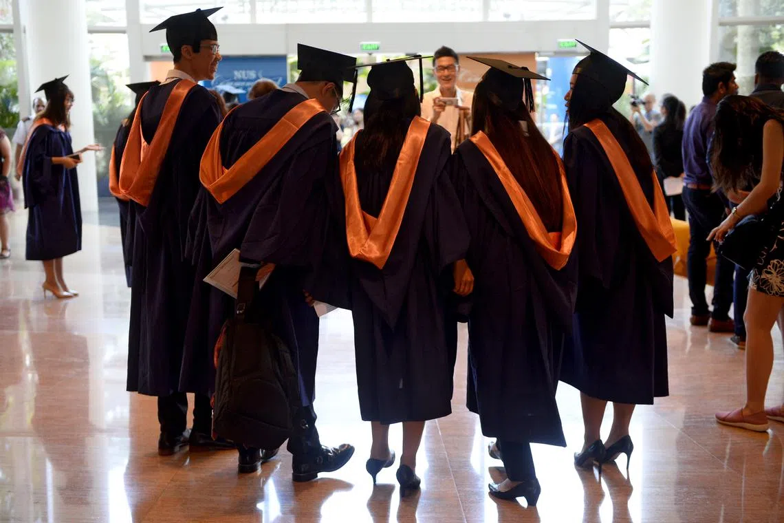 National University of Singapore (NUS) graduates taking a group photo before the NUS Commencement ceremony held at the University Cultural Centre on 7 July 2016.
