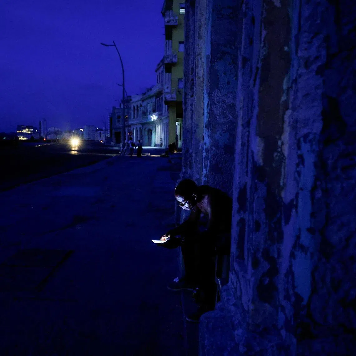 A man checks his phone outdoors in Havana as Cuba’s national electric grid collapsed at midday on July 6, leaving around 10 million people without power.