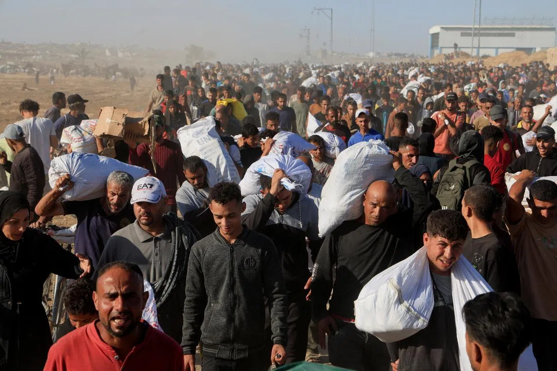 Palestinians carry aid supplies from the U.S.-backed Gaza Humanitarian Foundation, in Khan Younis, in the southern Gaza Strip, May 29, 2025. REUTERS/Hatem Khaled