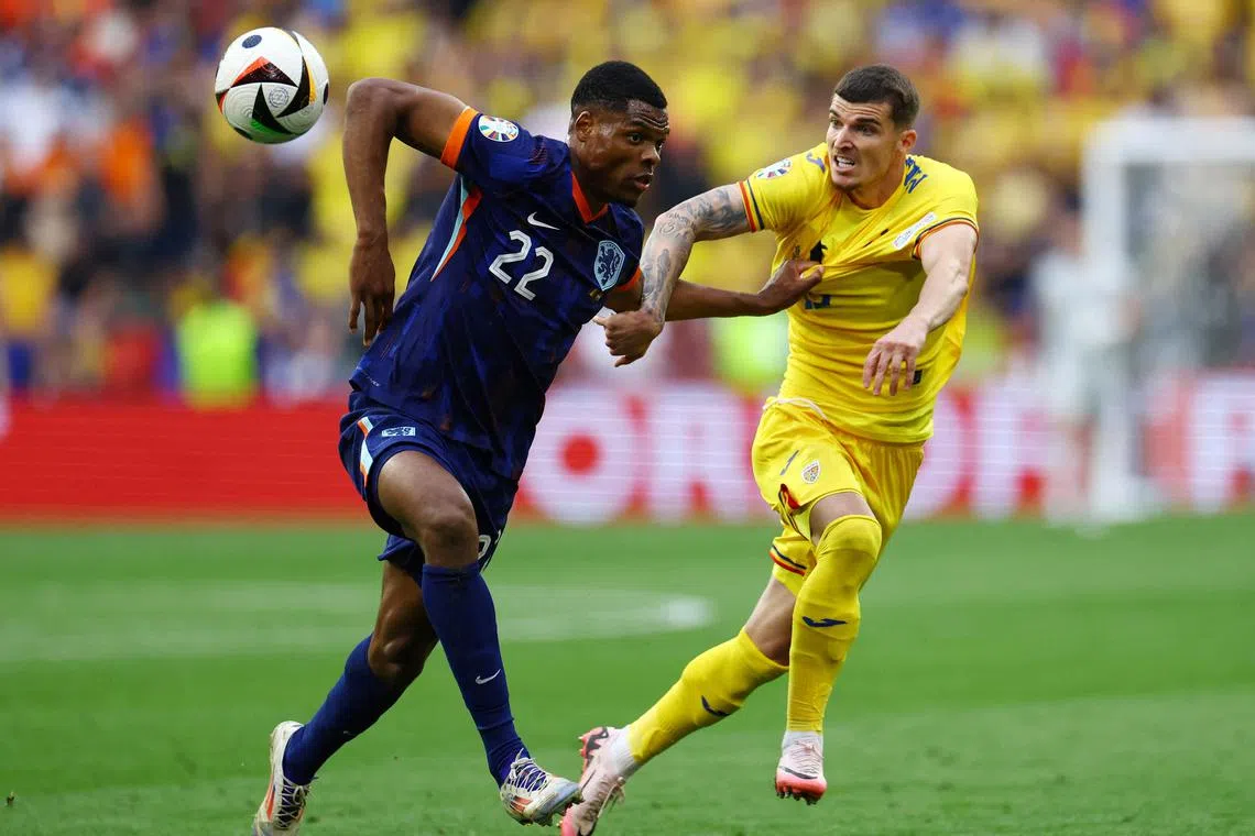 Soccer Football - Euro 2024 - Round of 16 - Romania v Netherlands - Munich Football Arena, Munich, Germany - July 2, 2024 Netherlands' Denzel Dumfries in action with Romania's Valentin Mihaila REUTERS/Lee Smith