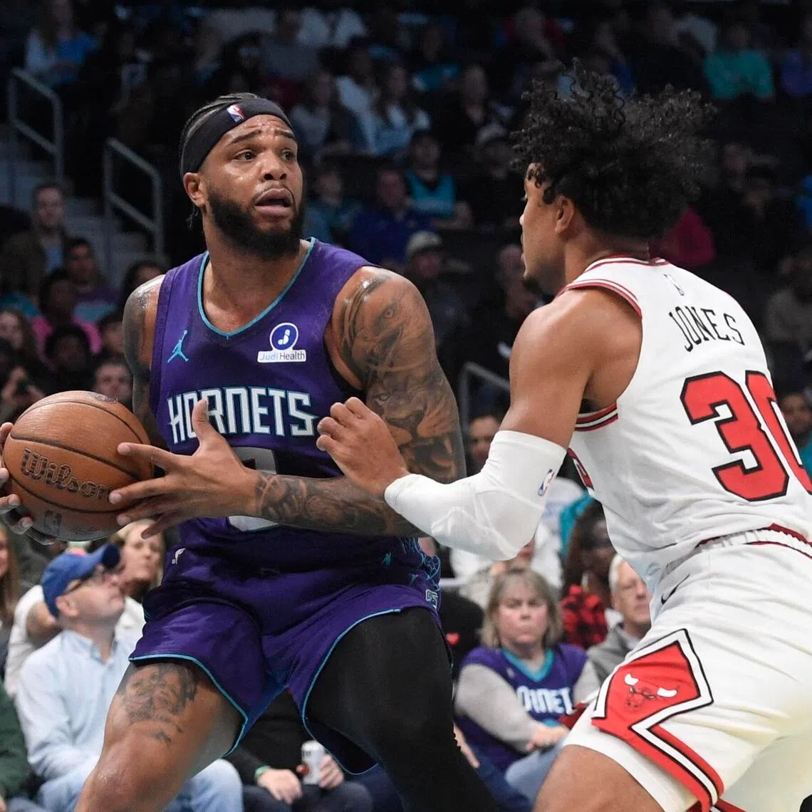Charlotte Hornets forward Miles Bridges looking to pass as he is defended by Chicago Bulls guard Tre Jones during the first half of the Hornets' 123-116 NBA win at the Spectrum Center on Nov 28, 2025.