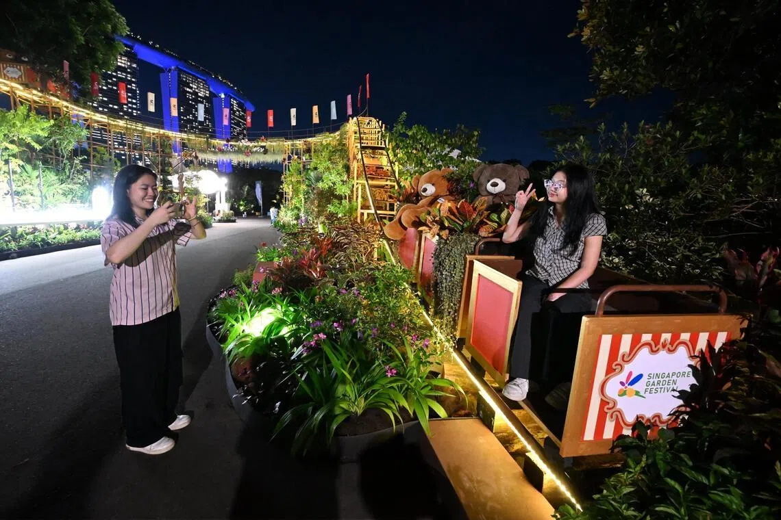 Two young visitors taking photos at the floral roller coaster at the Singapore Garden Festival on July 2.