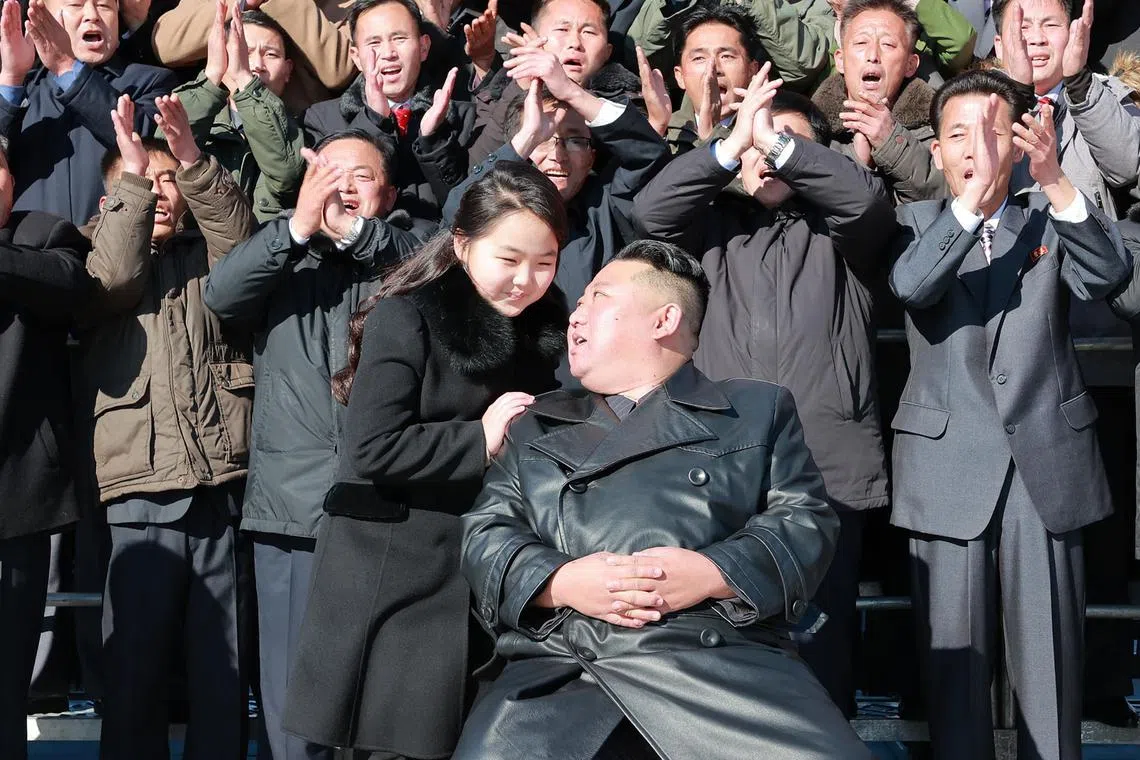 North Korean leader and his daughter with scientists, engineers and military officials involved in the test of a new ballistic missile.