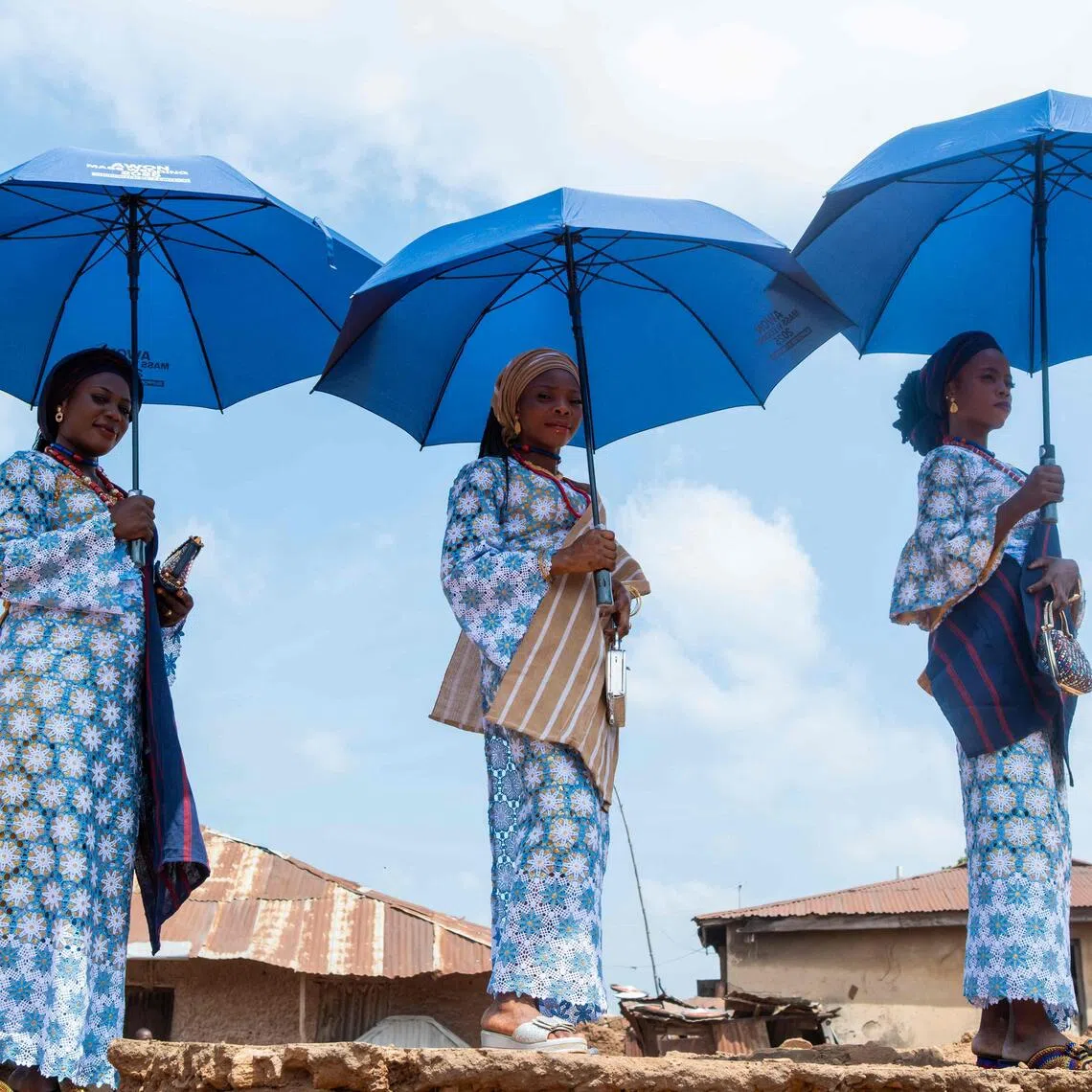 Brides pose for a photograph as they wait for the procession taking place during a mass wedding in Shao, Nigeria.