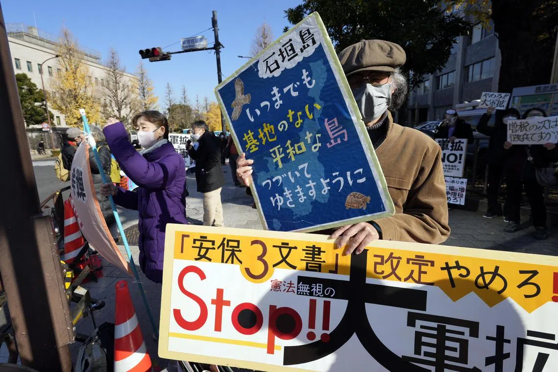 A man holding a placard reading "Stop the military expansion!" protesting against the increase of the defence budget in Tokyo on Dec 16, 2022.
