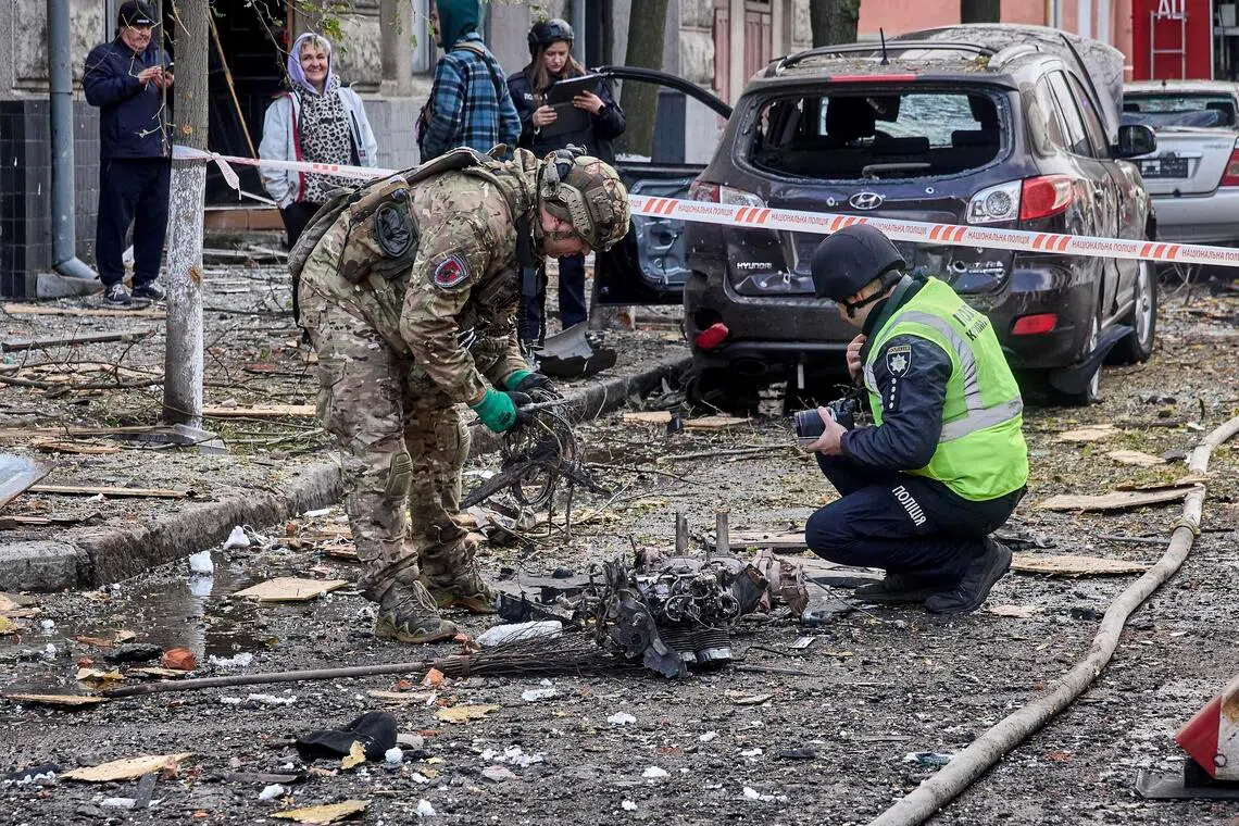 Ukrainian experts inspecting debris from a Russian drone at the site of an attack on a kindergarten in Kharkiv, northeastern Ukraine, on Oct 22.