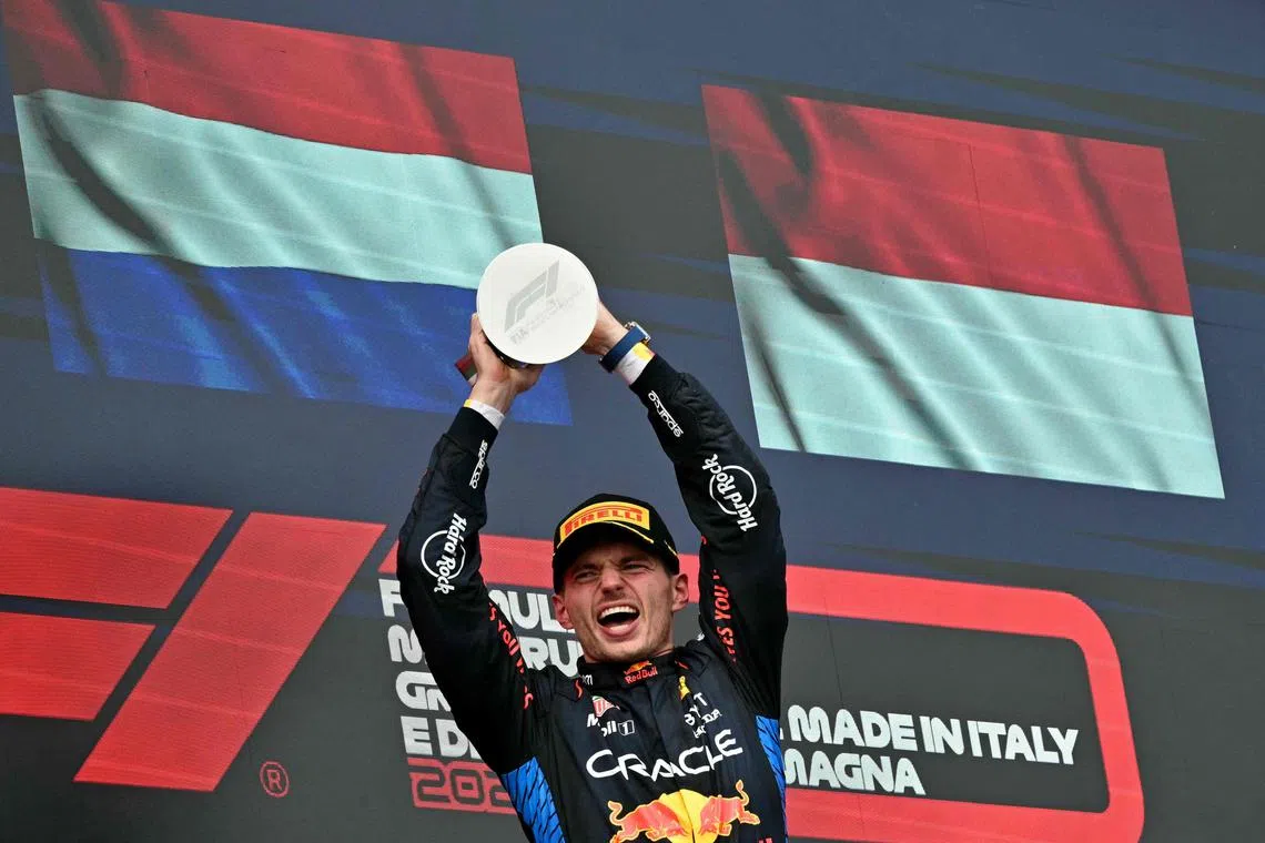 Race winner Red Bull's Dutch driver Max Verstappen holding his trophy on the podium of the Emilia Romagna Formula One Grand Prix at the Autodromo Enzo e Dino Ferrari racetrack in Imola on May 18.