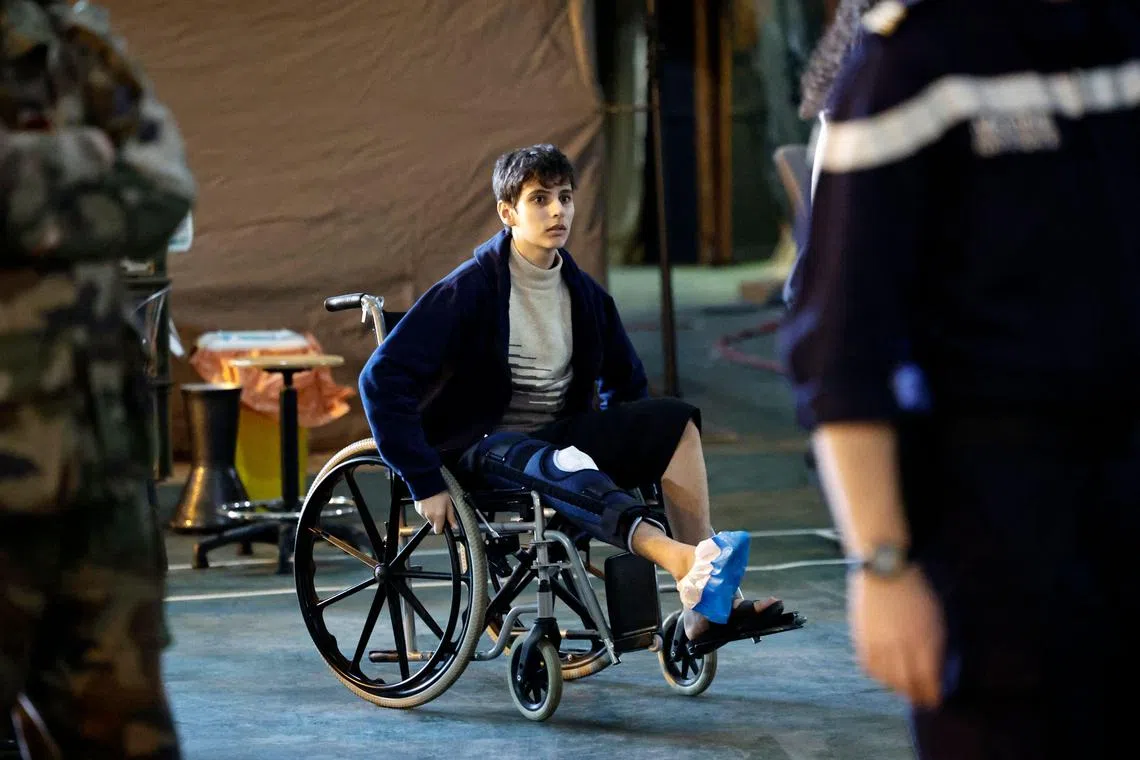 A Palestinian youth pushes his wheelchair aboard the French military ship Dixmude.