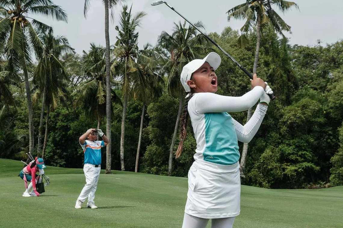 Indonesia’s Amira Permadi (right), 10, practicing ahead of the Mandiri Ciputra Golfpreneur Junior World Championship 2025, a two-day tournament with 141 players aged 10 to 18 from 21 countries, at the Damai Indah Golf PIK course in Jakarta on June 9, 2025. 