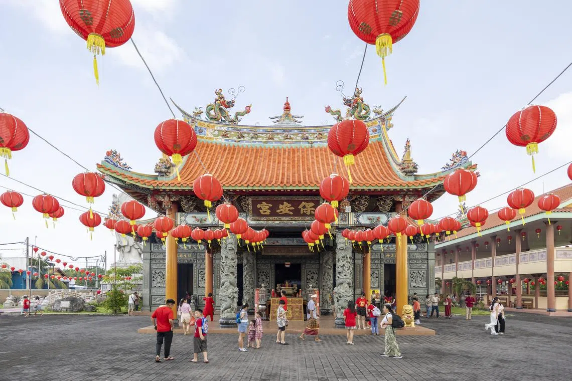 People attend a prayer during Chinese Lunar New Year celebrations at a temple in Denpasar, Bali, on Jan 29.