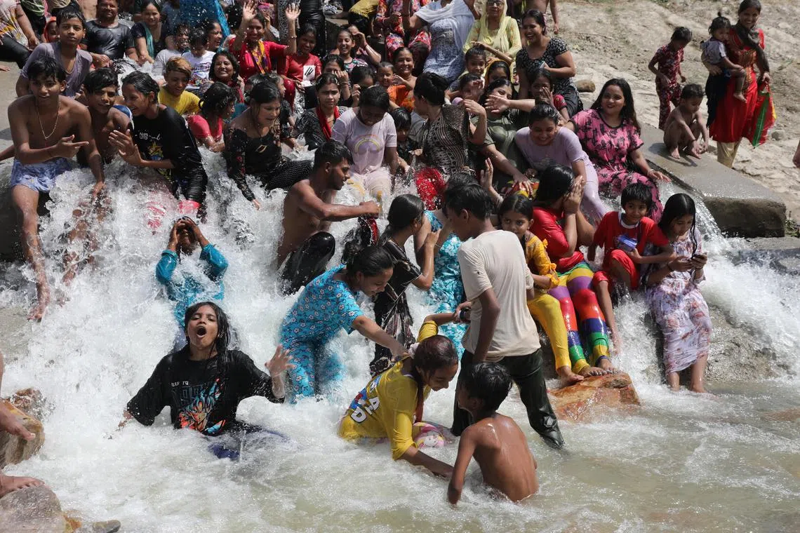 People take a dip at a lake in New Delhi as the temperature in India’s capital soared to 50 deg C.