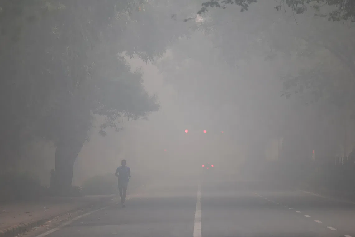 A man jogs on a road shrouded in smog on the day after Diwali, in New Delhi, India, on Oct 21.