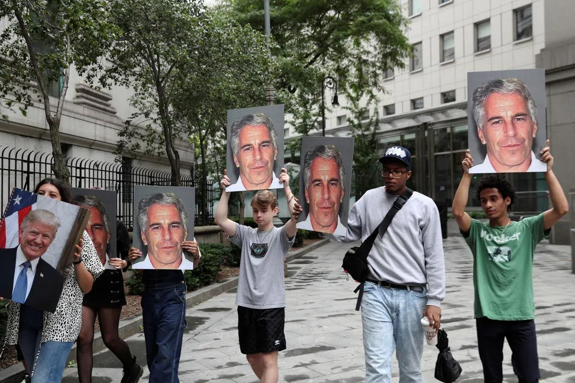 Demonstrators hold signs aloft protesting Jeffrey Epstein, as he awaits arraignment in the Southern District of New York on charges of sex trafficking of minors and conspiracy to commit sex trafficking of minors, in New York, U.S., July 8, 2019. REUTERS/Shannon Stapleton