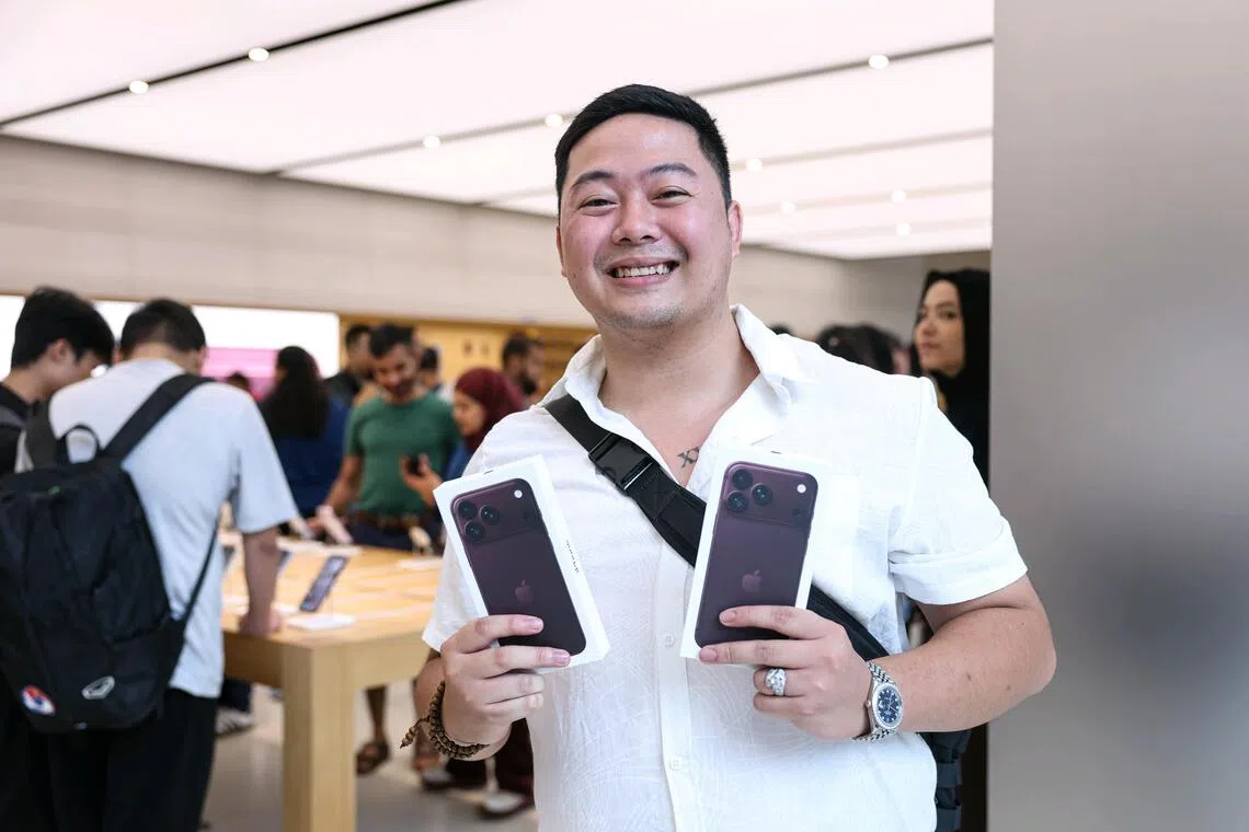 Vietnamese tourist Tran Anh Vu posing with his new iPhone 18 Pro. He flies in from Vietnam with a few friends every year to buy the latest iPhones for himself, his mother and his wife.
