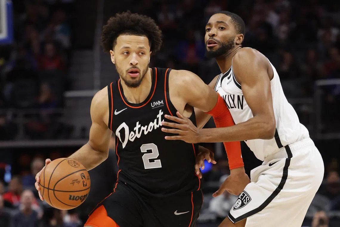 Detroit Pistons guard Cade Cunningham dribbles while defended by Brooklyn Nets forward Mikal Bridges in the first half at Little Caesars Arena.