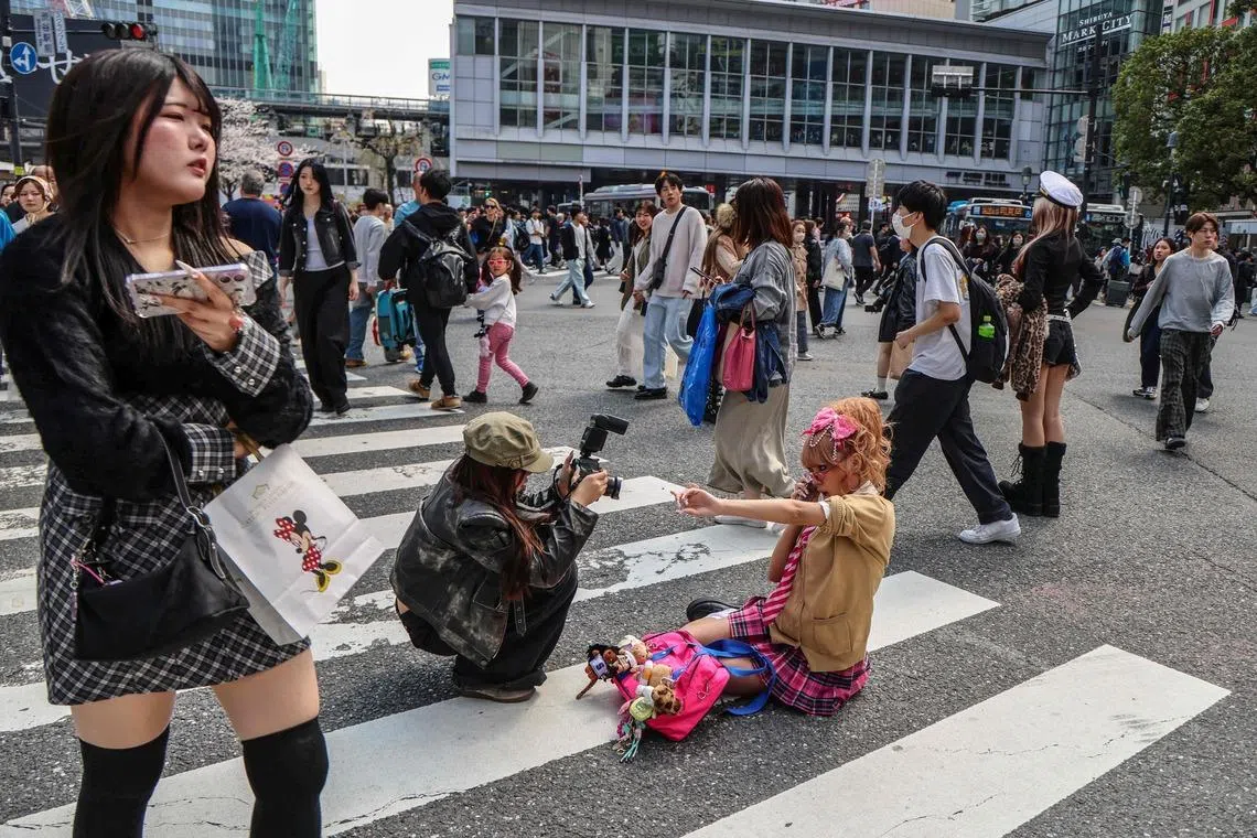 A woman posing for photographs at the famous Shibuya crossing in Tokyo, Japan on March 30, 2026. The crossing is the busiest in the world. 