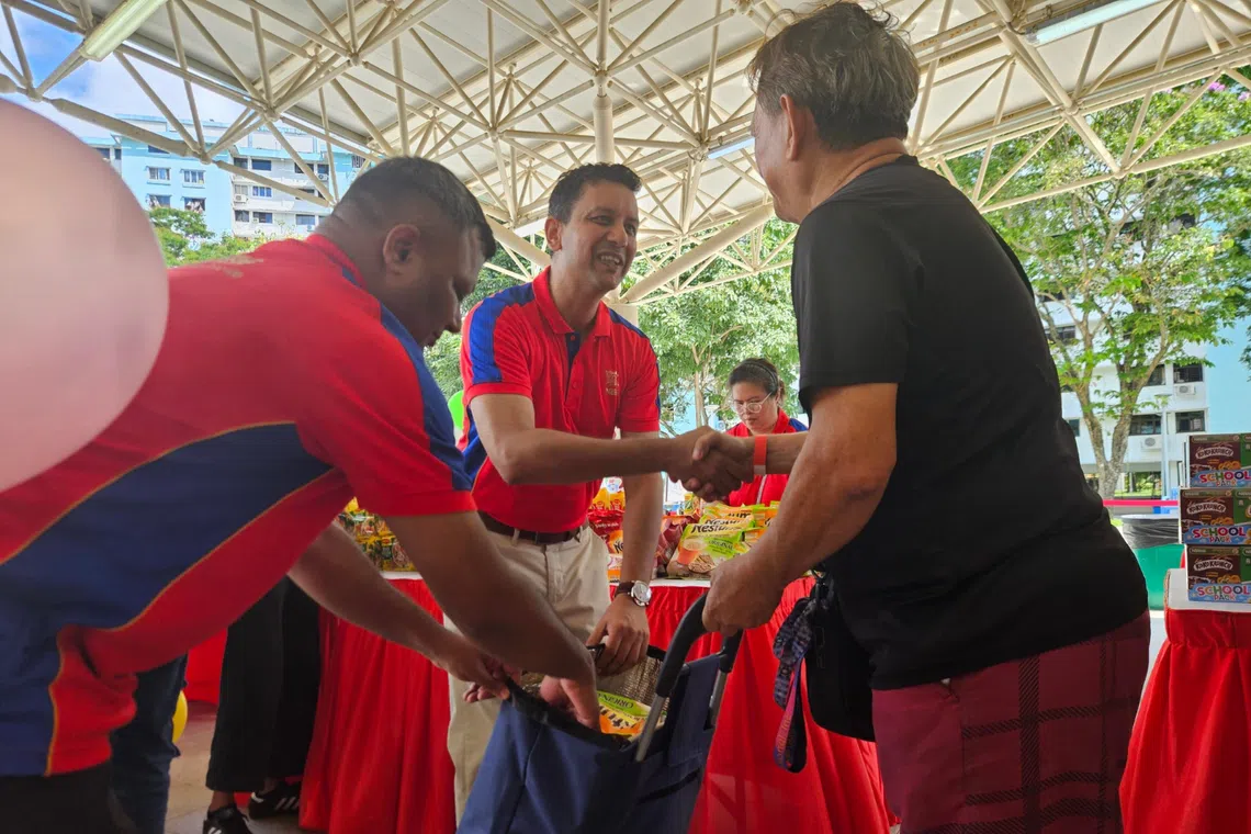 rajat kumar jain managing director of nestle singapore distributing food product hampers to families at the nestle carnival