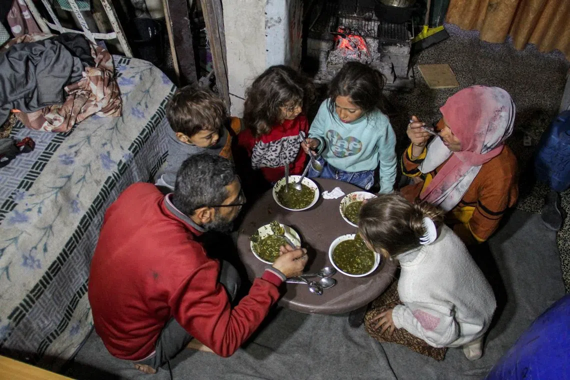 Palestinian man Wael Al-Attar eats Khobiza with his family as they break their fast during the holy month of Ramadan.