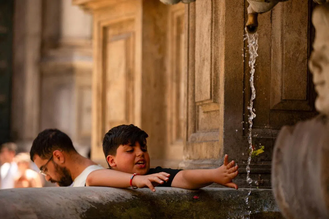 FILE PHOTO: A child cools off during a heatwave in Palermo, Sicily, Italy July 17, 2024. REUTERS/Antonio Cascio/File Photo