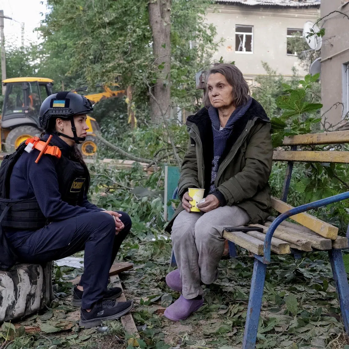An emergency psychologist talks to a resident at the site of an apartment building hit by a Russian air strike, amid Russia's attack on Ukraine, in Kharkiv, Ukraine June 20, 2026. REUTERS/Sofiia Gatilova
